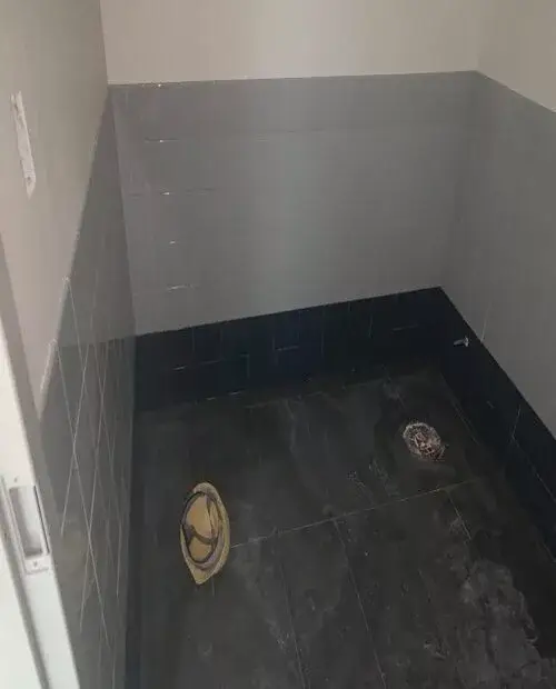 Black ceramic tiles installed over bathroom floor