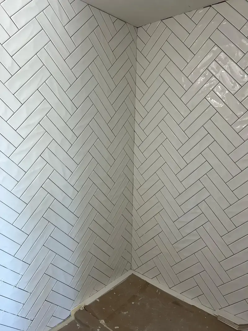 Herringbone-pattern wall tile installation by Morina Brothers