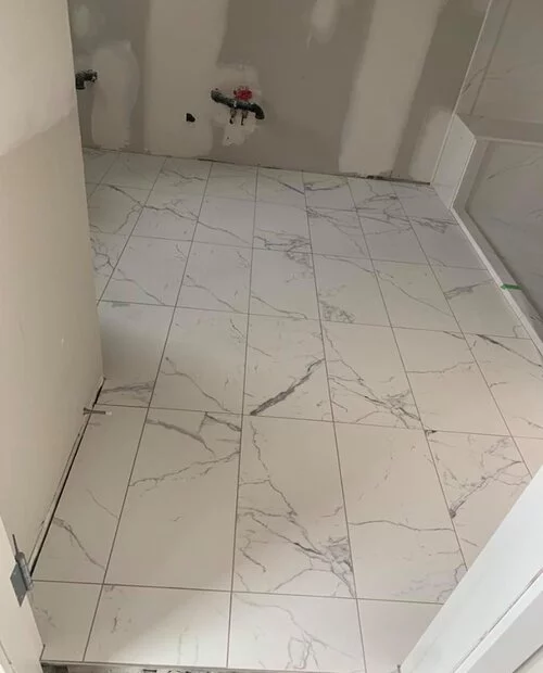 White tiles with black shadow nuances - bathroom installation in process