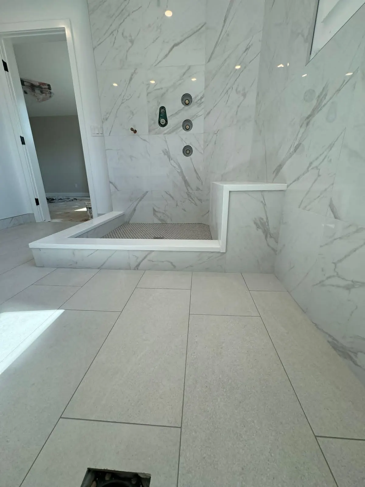 Ground view of a tiled shower - tiled floor, base, curb, and walls