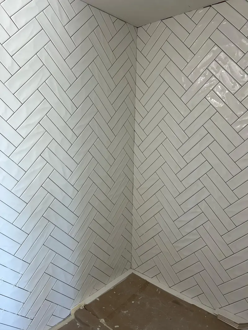 Herringbone-pattern wall tile installation by Morina Brothers