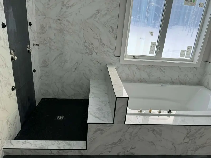 Pebble tile shower base paired with porcelain marble-look wall tile