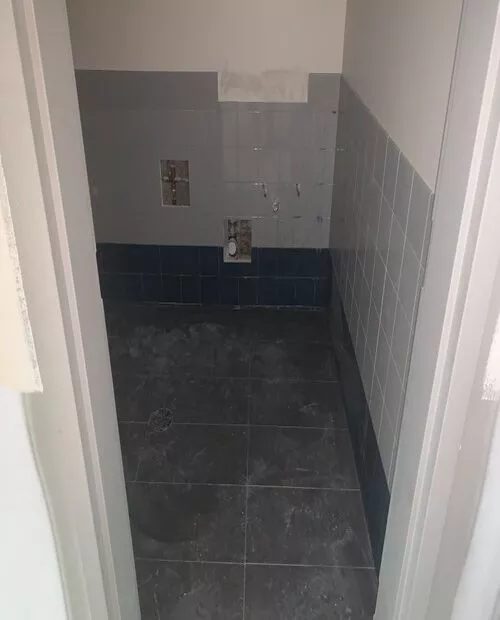 newly installed tiles at a bathroom floor. View from the door
