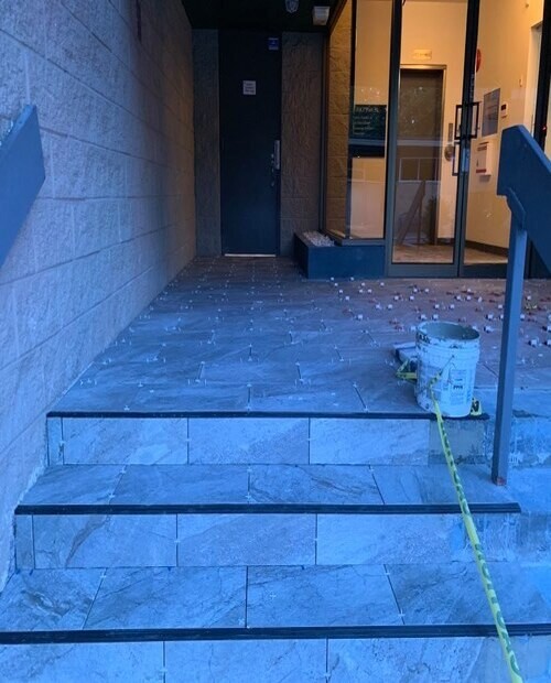 installing tiles over stairs at entrance of commercial building